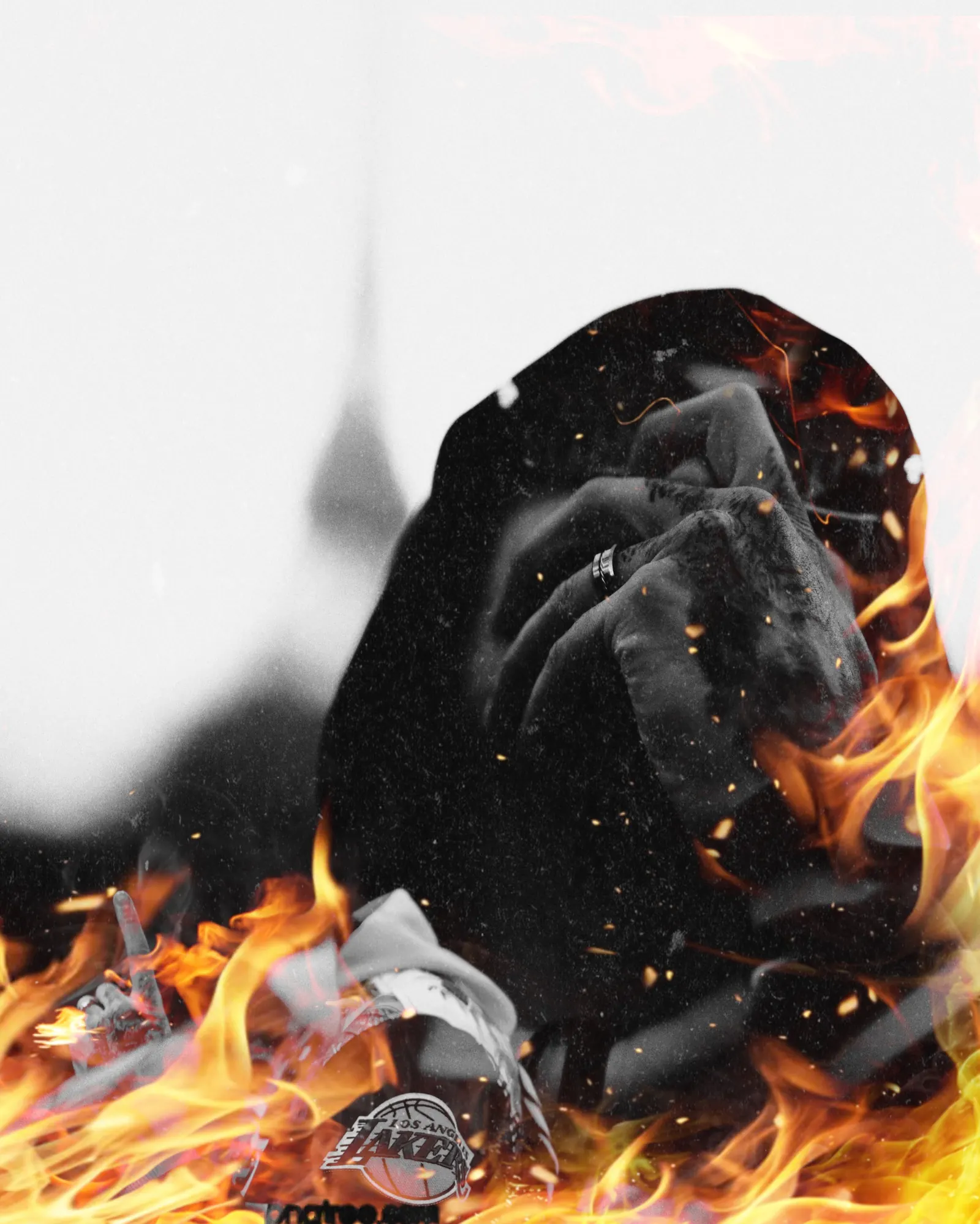 Personne en noir et blanc, visage masqué par les mains, entourée de flammes ardentes.